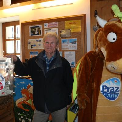Alain Gac pose devant l'urne, à l'office de tourisme, où le public peut déposer les tickets reçus auprès des entreprises participant au Jeu des 1 000 Draz. À ses côtés, la mascotte Draz - Yann Jaccaz