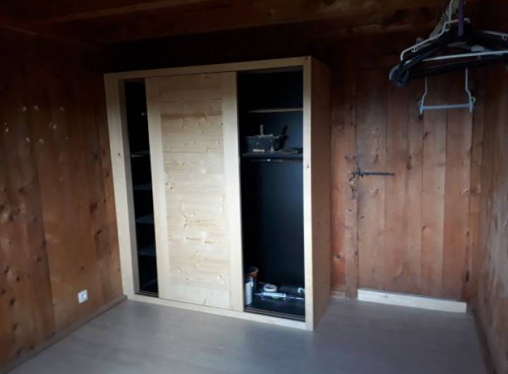 Placard avec les joues et le dessus en sapin, dont l'aménagement intérieur, les séparations et les rayons sont en mélaminé