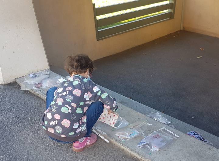 Chaque élève possède une pochette rouge pour y insérer son masque usagé du matin et une pochette verte pour conserver son masque propre de l'après-midi.