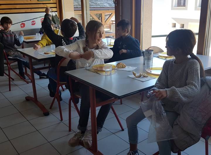 Au moment du déjeuner, les élèves retirent leur masque usagé et le rangent dans leur pochette rouge. Masque qui sera lavé par les parents le soir.