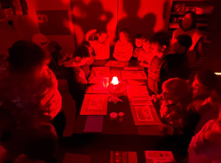 Dépôt d’objets sur des feuilles de papier sous une lumière rouge – Margaux Meurisse