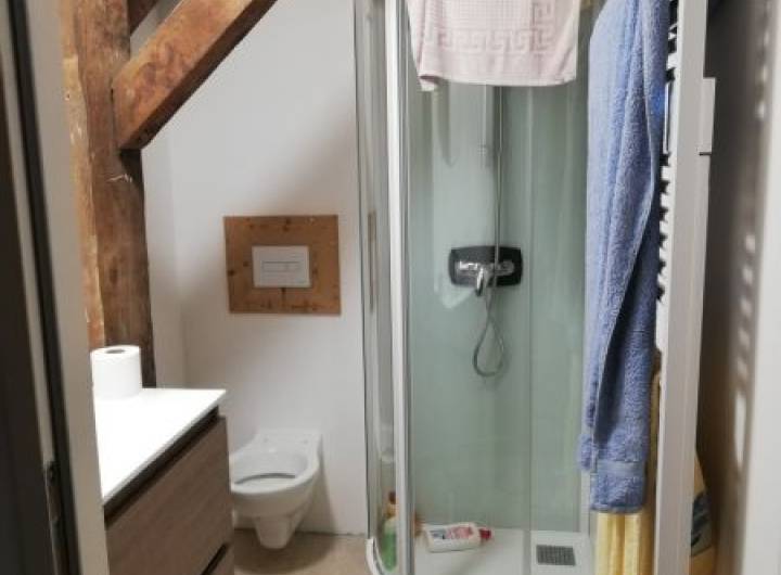 Salle d'eau comprenant un meuble vasque avec miroir, une cabine de douche de 80 x 80 cm et un sèche-serviettes