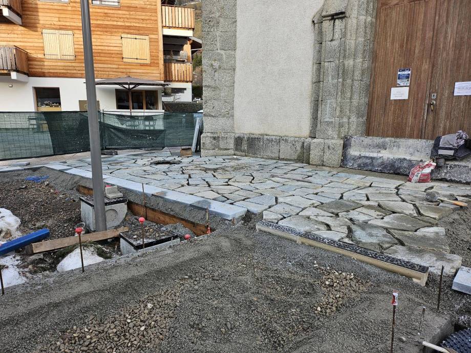 Dallage aux formes variables en cours de pose autour de l'église, photographié le 08/12/2025 - Marie-Anaïs Lien